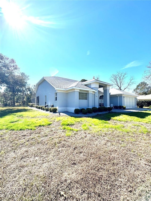 ranch-style house with a garage and a front lawn