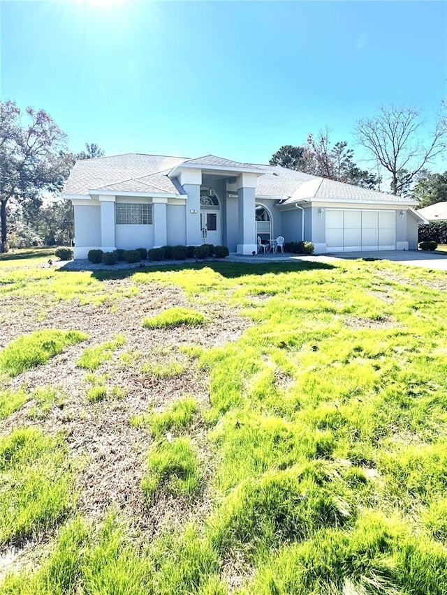 ranch-style home with a garage and a front yard