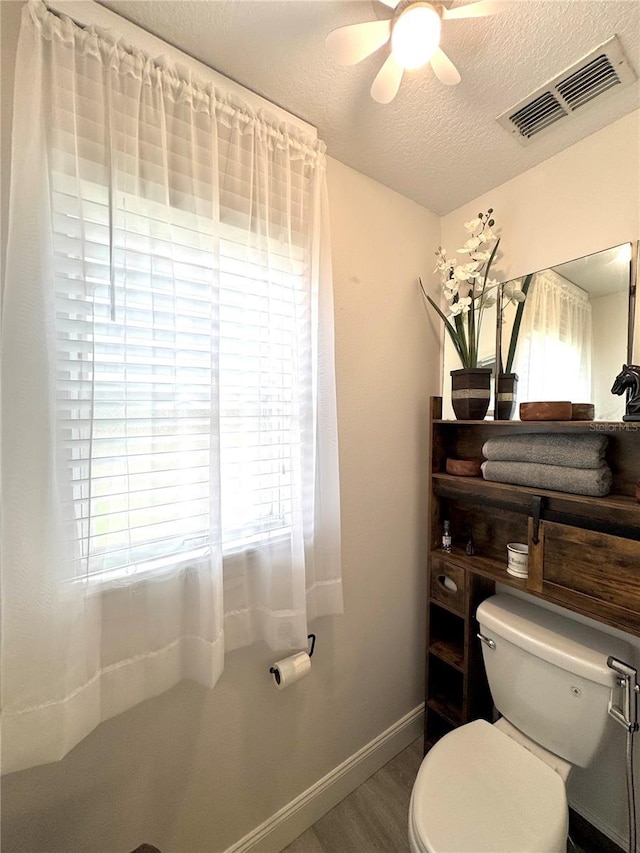 bathroom featuring hardwood / wood-style floors, a textured ceiling, ceiling fan, and toilet