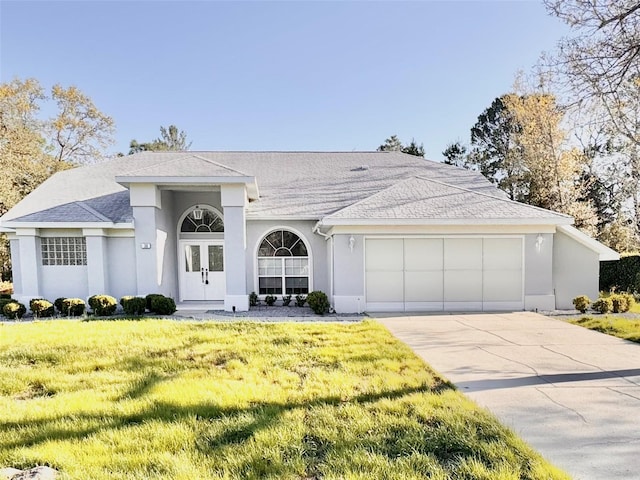 view of front of home featuring stucco siding, driveway, an attached garage, and a front lawn