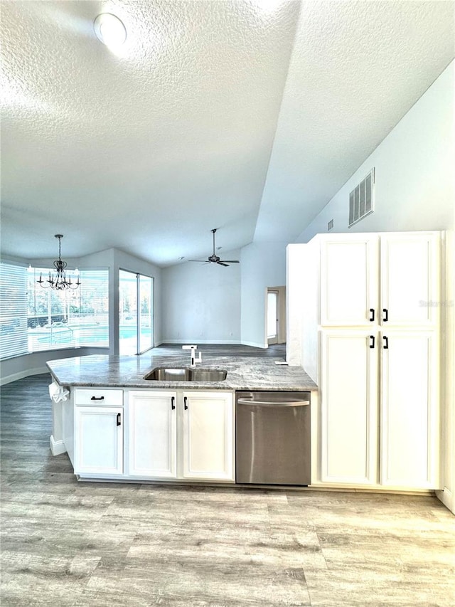 kitchen with visible vents, lofted ceiling, a sink, white cabinets, and dishwasher