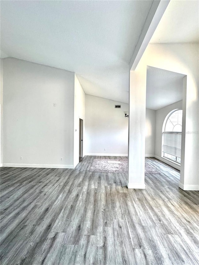 unfurnished room with visible vents, a textured ceiling, baseboards, and wood finished floors