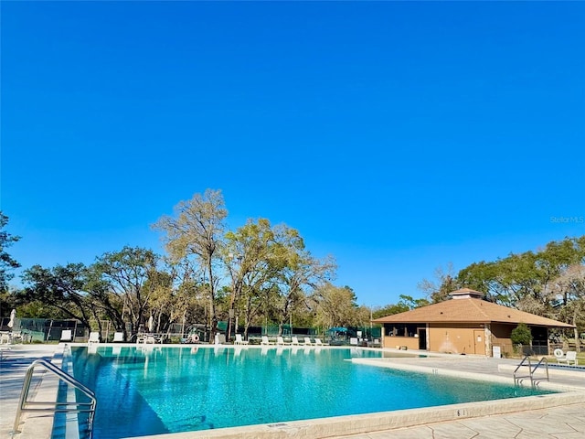 pool with a patio and fence