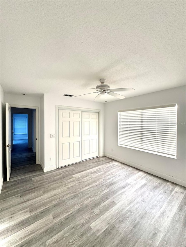 unfurnished bedroom featuring a closet, baseboards, and wood finished floors