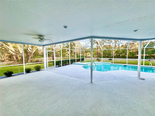 outdoor pool with glass enclosure, a patio, and a ceiling fan