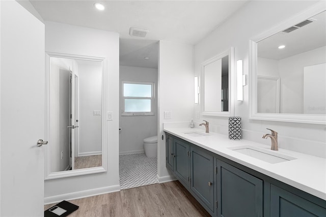 bathroom with hardwood / wood-style flooring, vanity, and toilet