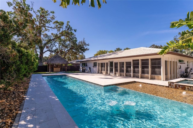 view of swimming pool with a patio area, a sunroom, and an in ground hot tub