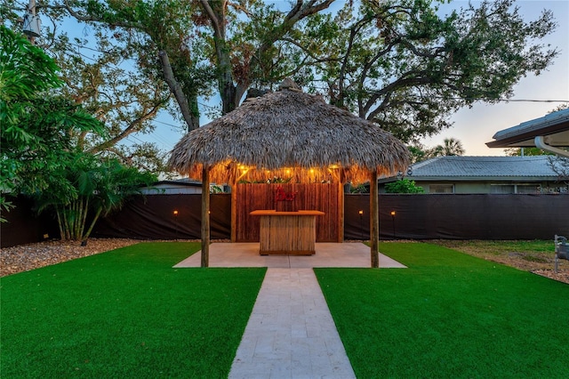 yard at dusk featuring a patio