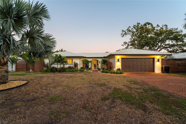 ranch-style house with a garage and a lawn