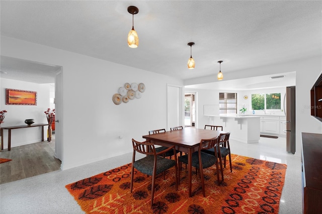 carpeted dining area featuring a textured ceiling