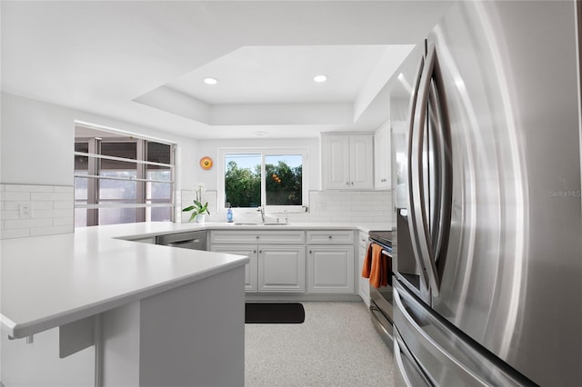 kitchen featuring white cabinetry, tasteful backsplash, kitchen peninsula, and appliances with stainless steel finishes