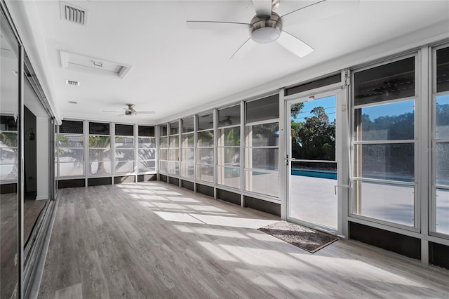 unfurnished sunroom featuring ceiling fan and plenty of natural light