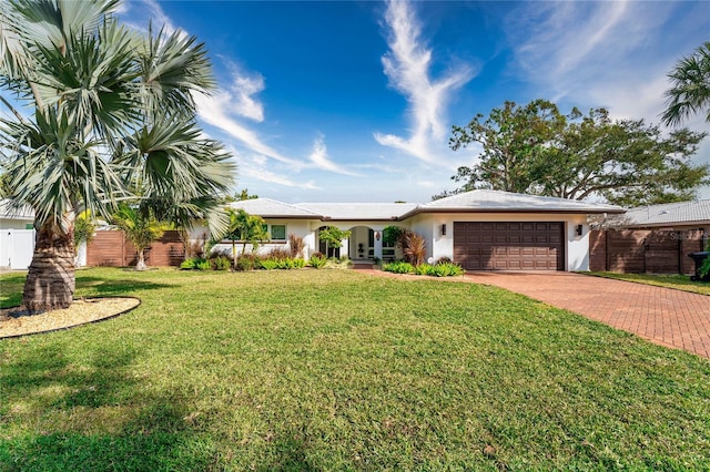 ranch-style house featuring a garage and a front lawn