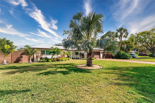 single story home featuring a garage and a front lawn