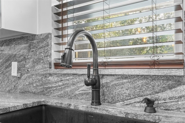 room details with sink, stone counters, and tasteful backsplash