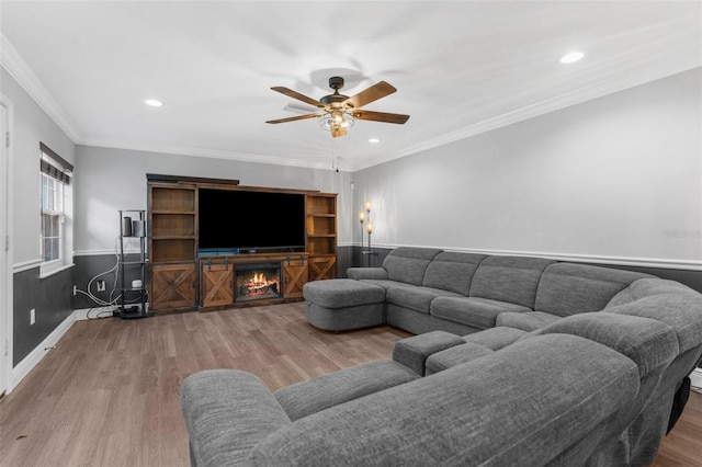 living room featuring crown molding, ceiling fan, and wood-type flooring