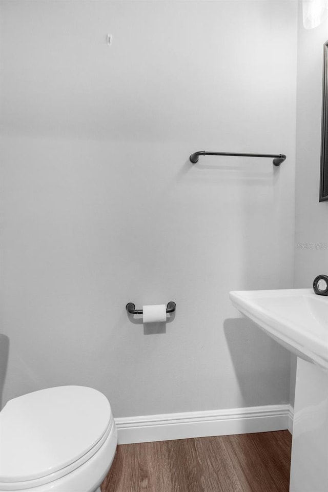 bathroom with wood-type flooring and toilet