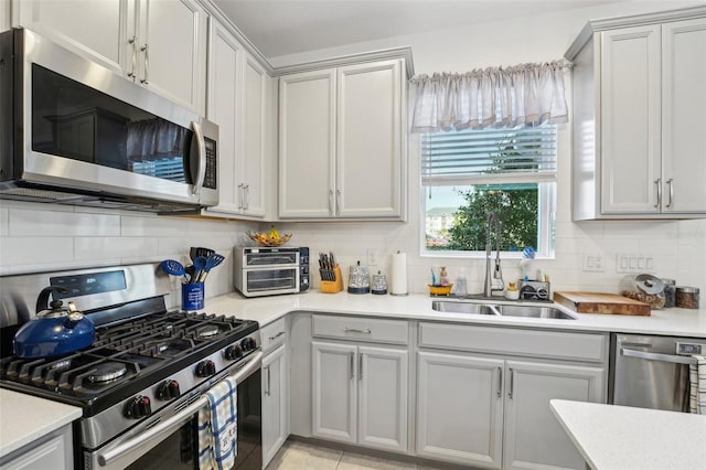 kitchen with stainless steel appliances, sink, and backsplash