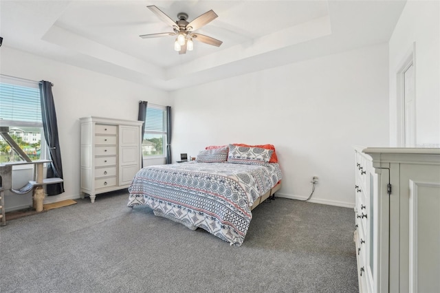 bedroom with carpet floors, a raised ceiling, and ceiling fan