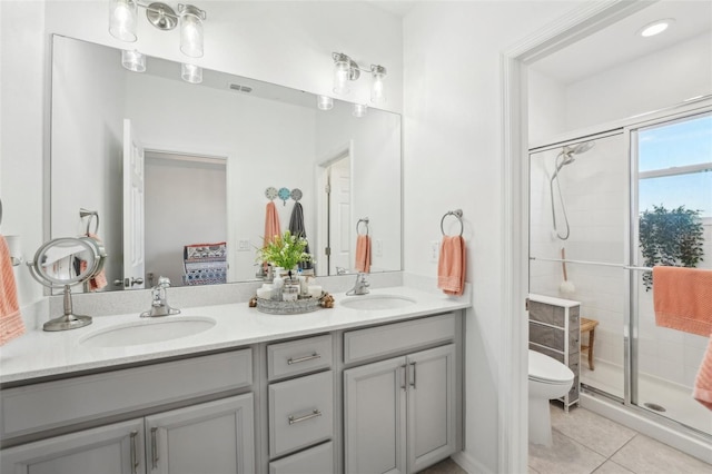 bathroom featuring tile patterned flooring, vanity, toilet, and walk in shower