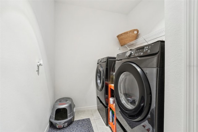 laundry area featuring light tile patterned flooring and washing machine and dryer