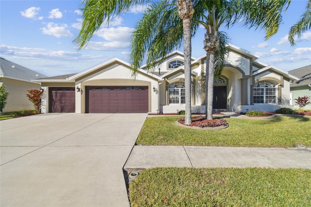 ranch-style house featuring a front lawn and a garage