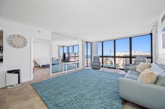 living room with plenty of natural light, floor to ceiling windows, and a textured ceiling