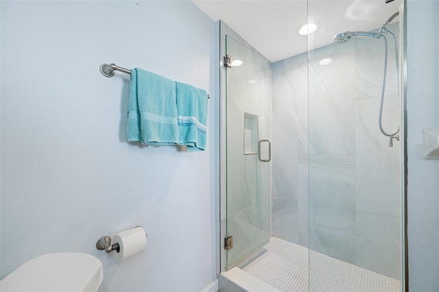 bathroom with a shower with shower door and toilet