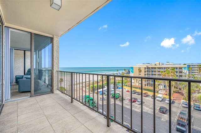 balcony with a water view and a view of the beach