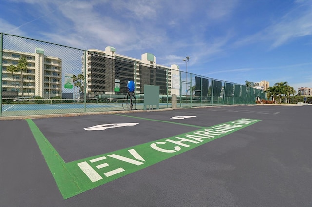 view of vehicle parking featuring tennis court