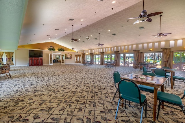 carpeted dining space featuring high vaulted ceiling and a textured ceiling