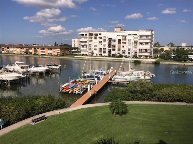 view of dock with a water view and a lawn