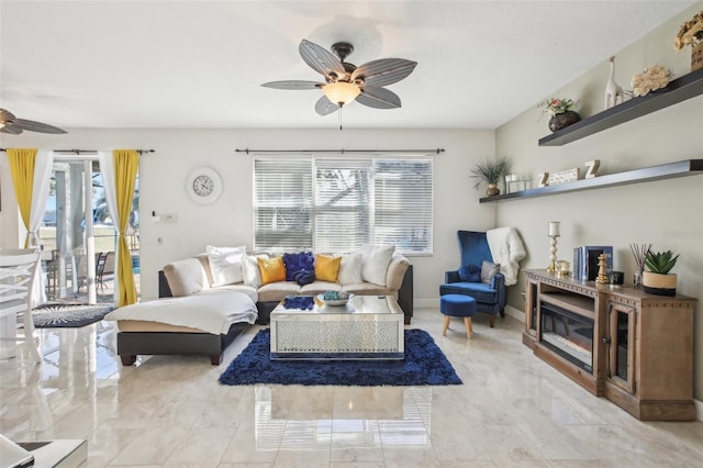 living room with a fireplace and ceiling fan