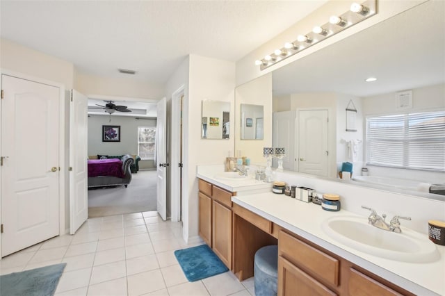 bathroom with tile patterned floors, ceiling fan, a washtub, and vanity