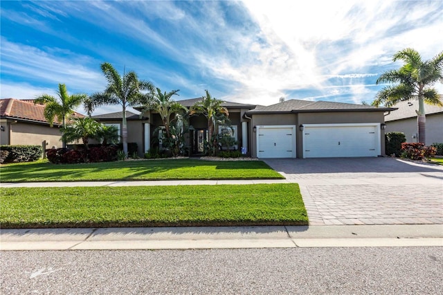 view of front of house featuring an attached garage, stucco siding, decorative driveway, and a front yard