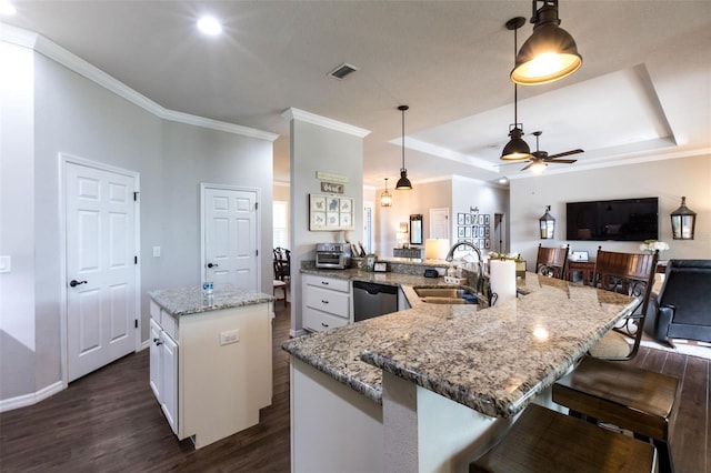 kitchen with dark wood-style floors, visible vents, stainless steel dishwasher, white cabinetry, and a sink