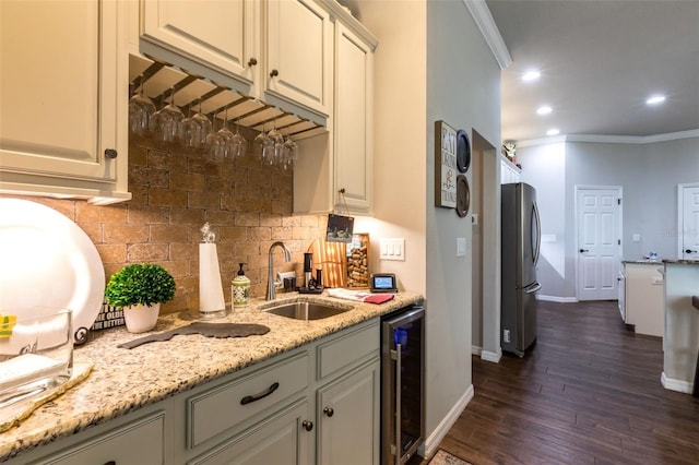 kitchen with beverage cooler, crown molding, a sink, and freestanding refrigerator