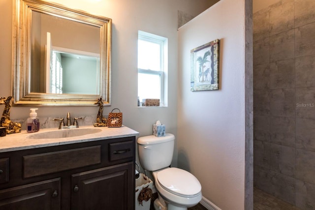 full bath with toilet, a tile shower, and vanity