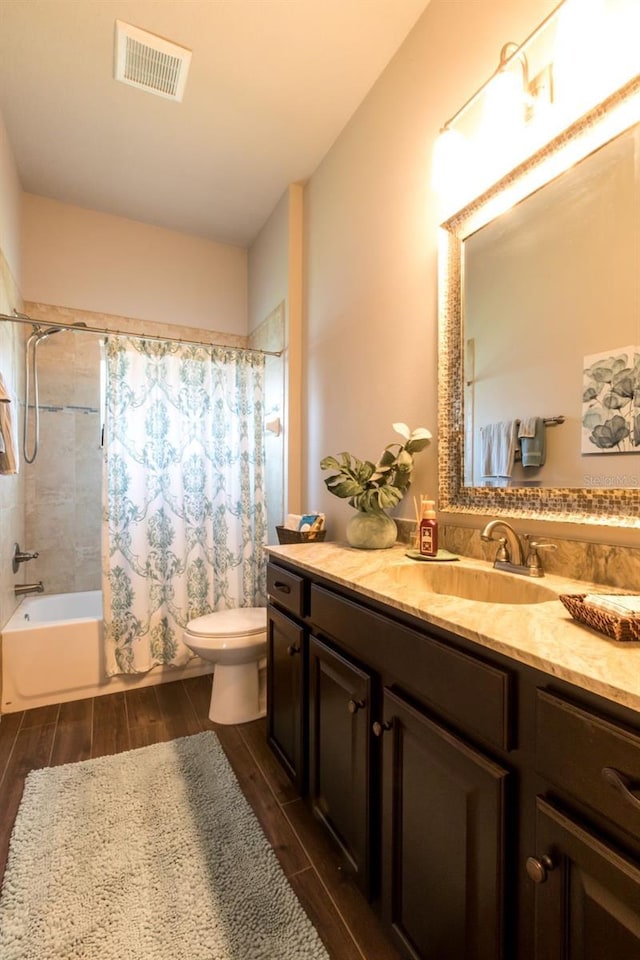 full bathroom with visible vents, toilet, wood tiled floor, shower / bath combination with curtain, and vanity