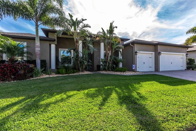 view of front of home with a garage, a front yard, driveway, and stucco siding