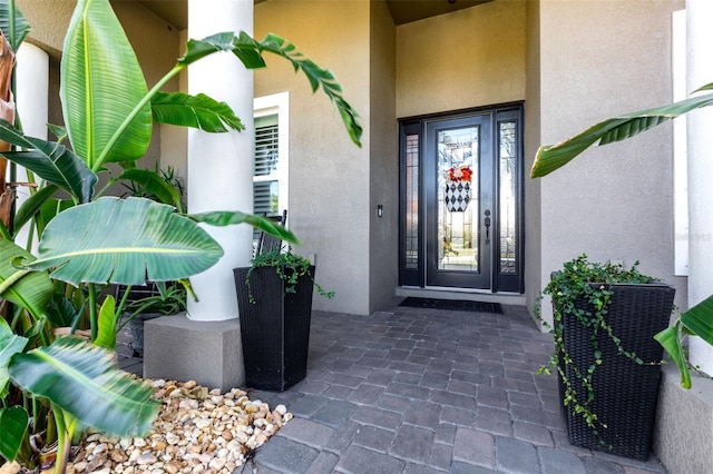 view of exterior entry featuring stucco siding