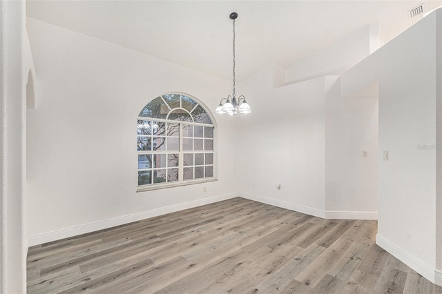 unfurnished dining area with hardwood / wood-style floors, high vaulted ceiling, and a notable chandelier