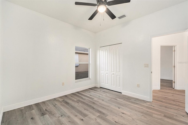 unfurnished bedroom featuring ceiling fan, a closet, and light wood-type flooring