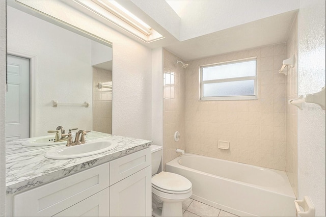 full bathroom with tile patterned flooring, vanity, tiled shower / bath combo, and toilet