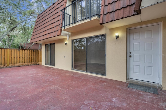 view of exterior entry with a patio area