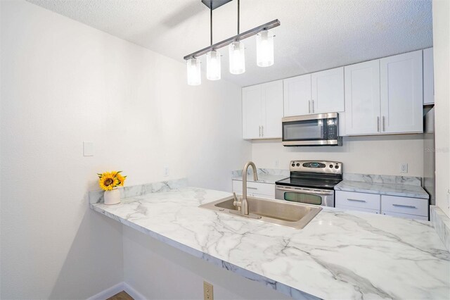 kitchen with decorative light fixtures, sink, appliances with stainless steel finishes, a textured ceiling, and white cabinets