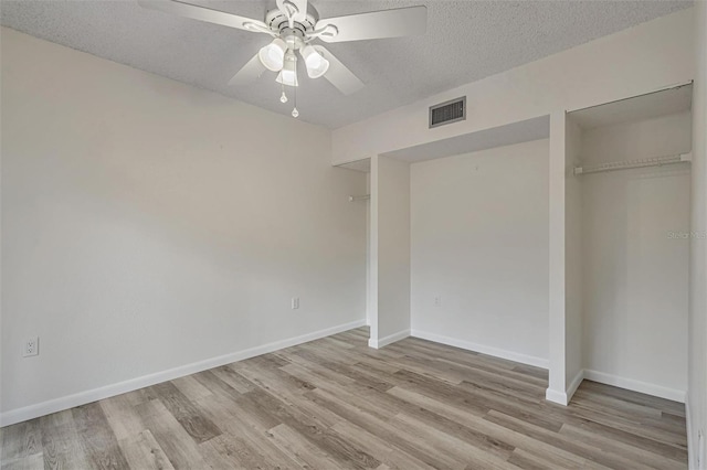 unfurnished bedroom featuring ceiling fan, a closet, a textured ceiling, and light hardwood / wood-style floors