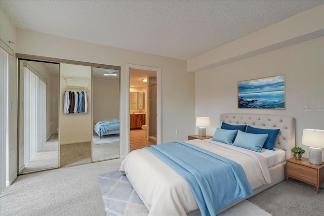 carpeted bedroom featuring a textured ceiling, a closet, and connected bathroom