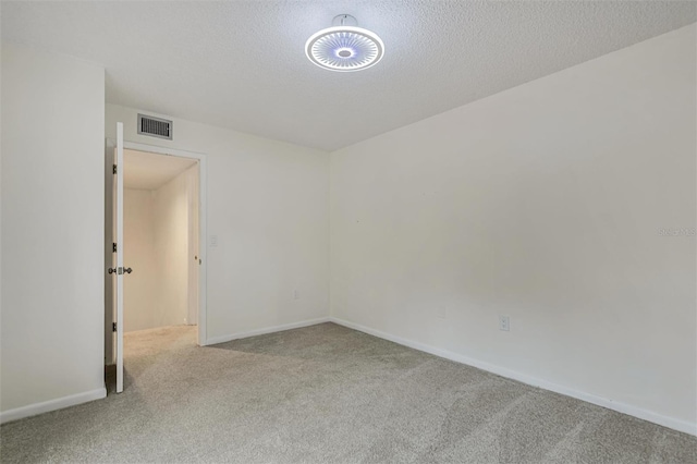 carpeted spare room featuring a textured ceiling