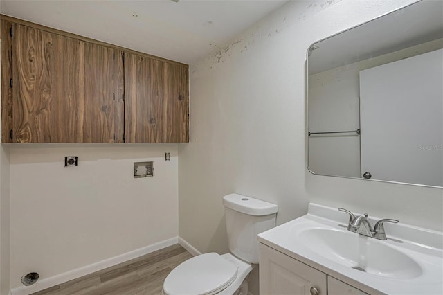 bathroom with hardwood / wood-style flooring, toilet, and vanity